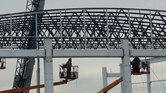 Close up of workers installing bowstring joists