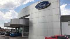Exterior of Ford dealership with car on lot