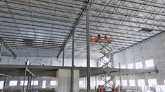 Workers on scissor-lift inspecting joists