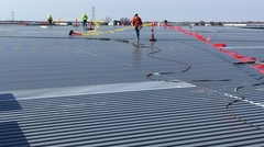 Workers finishing deck installation on warehouse roof