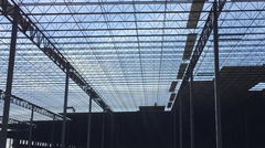 View looking up at steel deck staged for installation on steel joists